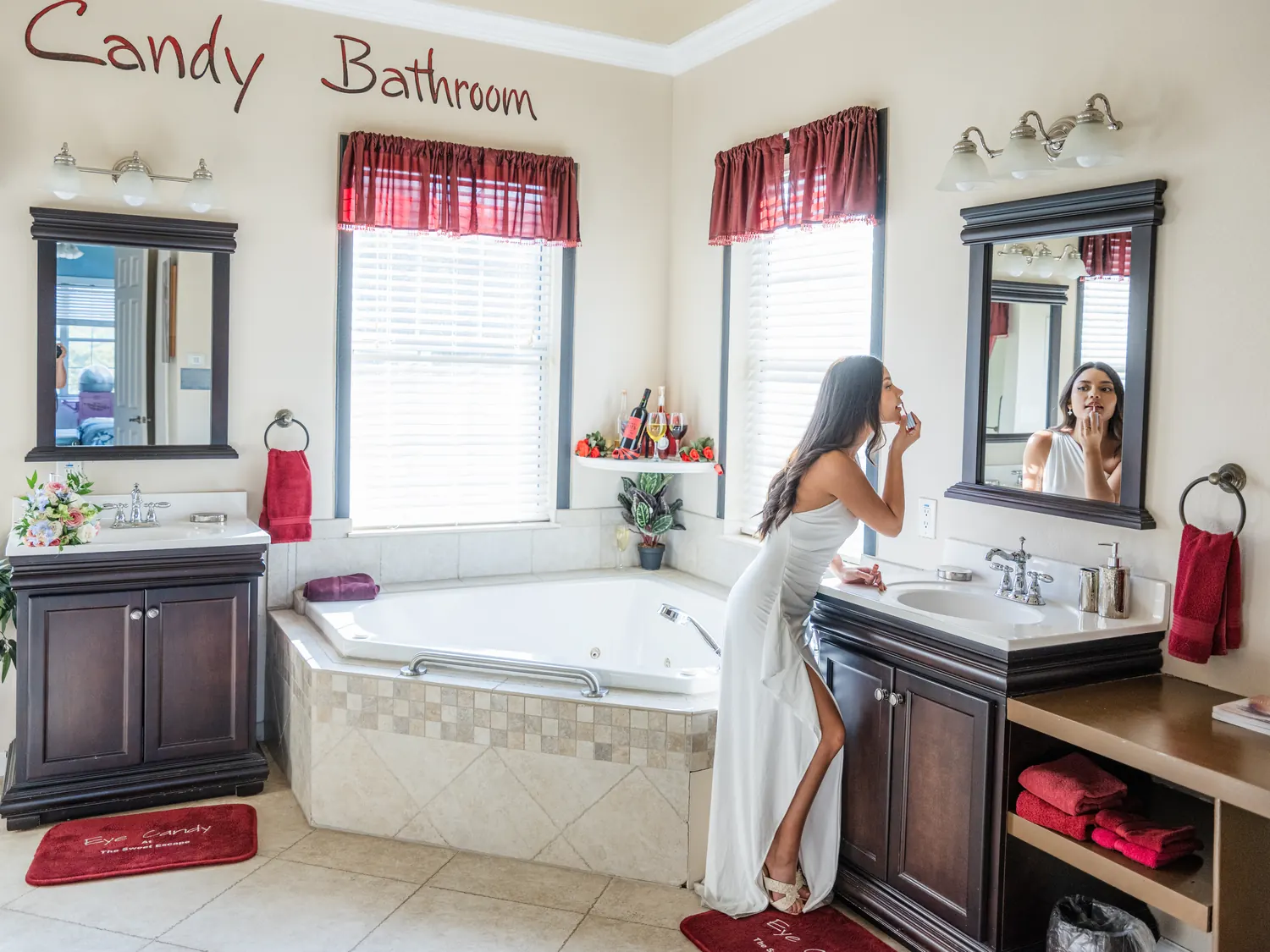 Bride applying lipstick at the vanity in the candy themed bathroom at The Sweet Escape House