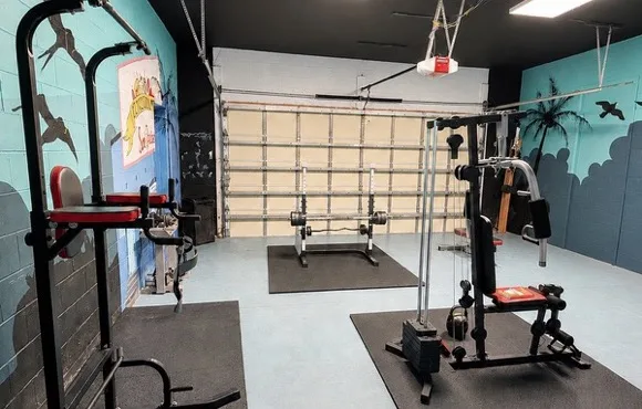Indoor gym with free weights and a cable machine at the Sweet Escape